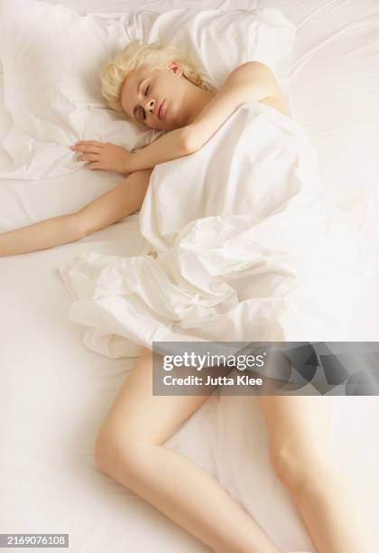 young woman sleeping in bed - semi dress stock pictures, royalty-free photos & images