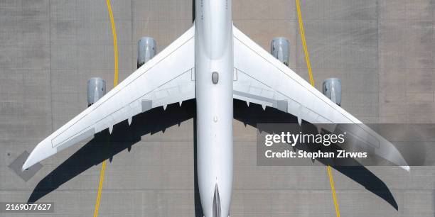 view from above white airplane on sunny airport tarmac - indústria aeroespacial imagens e fotografias de stock