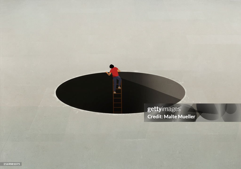 Man climbing ladder out of large hole