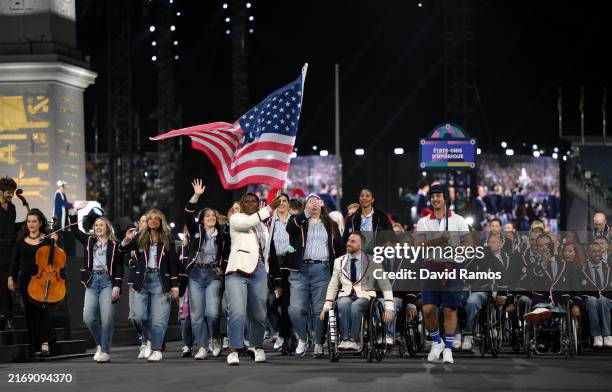 Nicky Nieves and Steve Serio, Flag Bearers of Team United States, hold their national flag as they parade during the opening ceremony of the Paris...