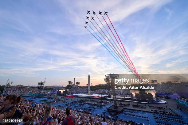 The Patrouille acrobatique de France perform a flyby whilst releasing smoke in the colours of the French flag during the opening ceremony of the...
