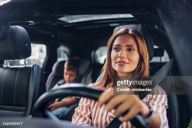mom driving son to school in car for back to school season - conduzir imagens e fotografias de stock