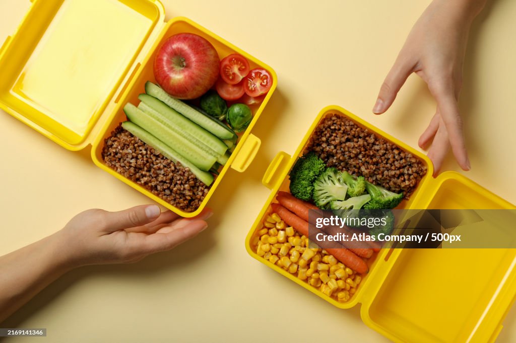 Yellow lunch box with buckwheat and fresh vegetables