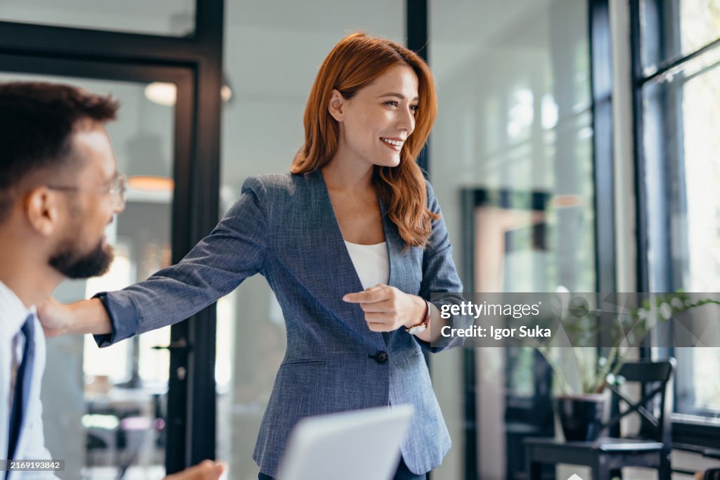 Mujer de negocios profesional liderando la reunión en un entorno de oficina moderno