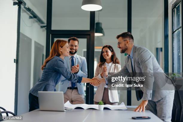 business meeting with handshake and blueprints on table - diplomacy stock pictures, royalty-free photos & images