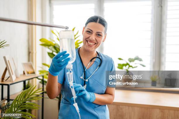 home care nurse preparing an iv drip indoors - hemodialise imagens e fotografias de stock
