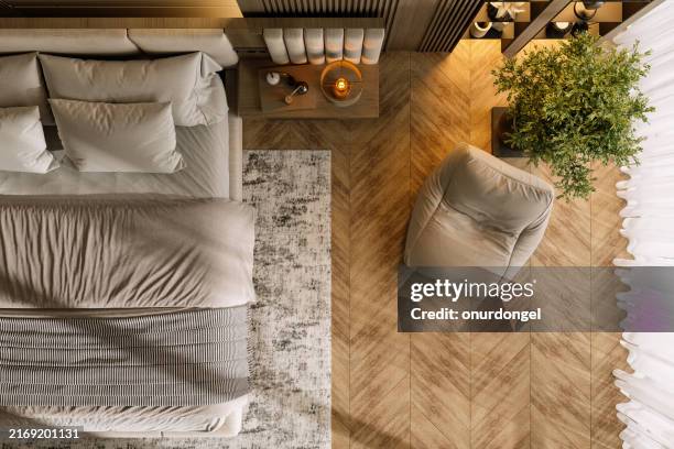 high angle view of modern bedroom interior with bed, side table, armchair and potted plant - kussen beddengoed stockfoto's en -beelden