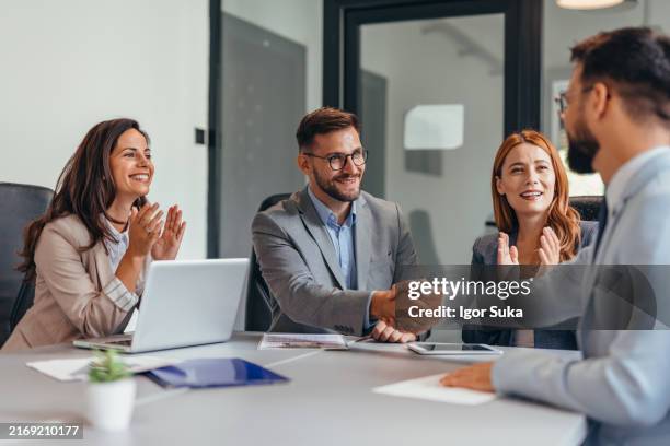 empresarios dándose la mano al otro lado de la mesa - director ejecutivo fotografías e imágenes de stock