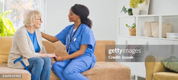 home nurse taking care of senior woman - senior home help stock pictures, royalty-free photos & images