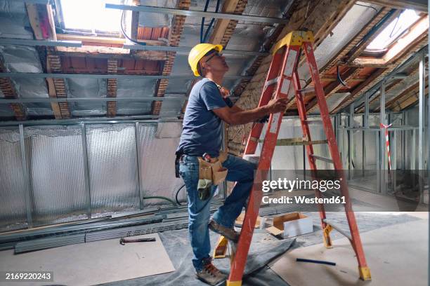 construction worker climbing on ladder at site - ladder stock pictures, royalty-free photos & images