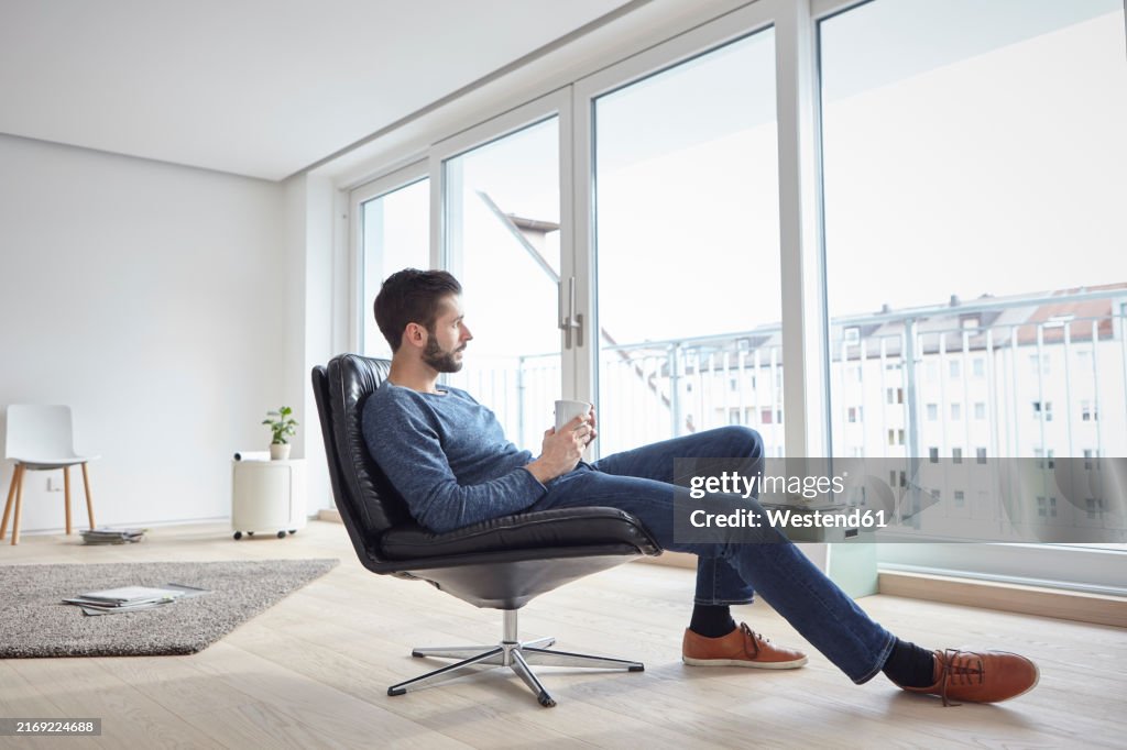 Young man relaxing in chair at new home