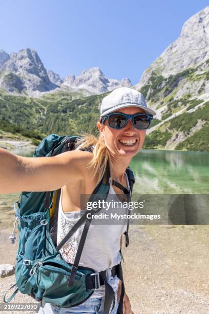 selfie joyeux : une femme souriante capturée au bord d’un lac de montagne pittoresque - état fédéré du tyrol photos et images de collection