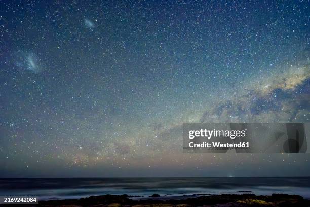 idyllic milky way over indian ocean at night in eastern cape, south africa - milky way stock pictures, royalty-free photos & images