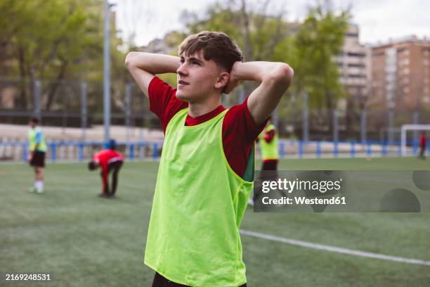 soccer player standing with hands behind head on field - sad football player stock pictures, royalty-free photos & images