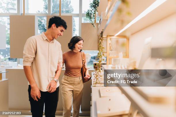 junges paar sucht produkte in einem juweliergeschäft - ring schmuck stock-fotos und bilder