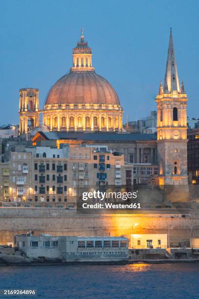 view of valletta with buildings at night - monumente stock-fotos und bilder
