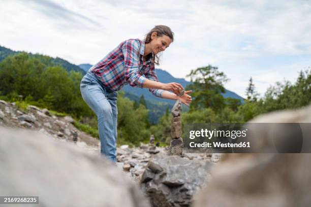 rock stacking photos and premium high res pictures -... Smiling Woman Stacking Rocks In Forest High-Res Stock Photo - Getty Images