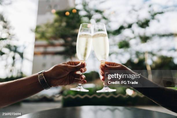 close-up of couple toasting with champagne on a restaurant - celebratory toast stock pictures, royalty-free photos & images