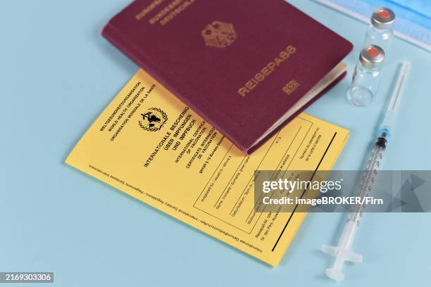 concept for travel restrictions for people without corona virus vaccination with international certificate of vaccination, german travel passport, syringe and vials - passeport vaccinal photos et images de collection