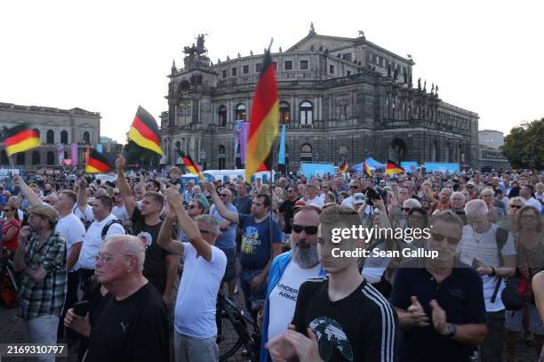 Supporters of the far-right Alternative for Germany political party gather with German flags in front of the Semperoper opera house at the final AfD...