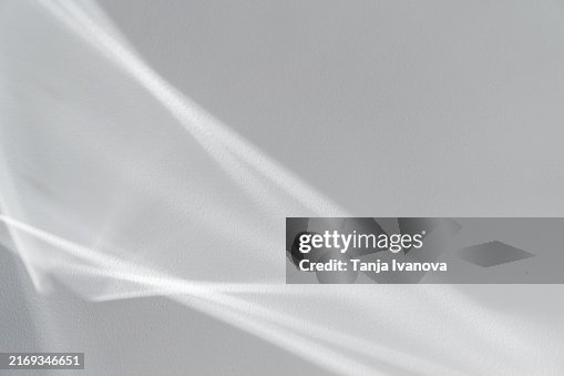 Texture of the surreal effect of refraction of white light on grey wall. Blurred background with abstract shadows and lights. Texture of the surreal effect of refraction of white light on grey wall. Blurred background with abstract shadows and lights.