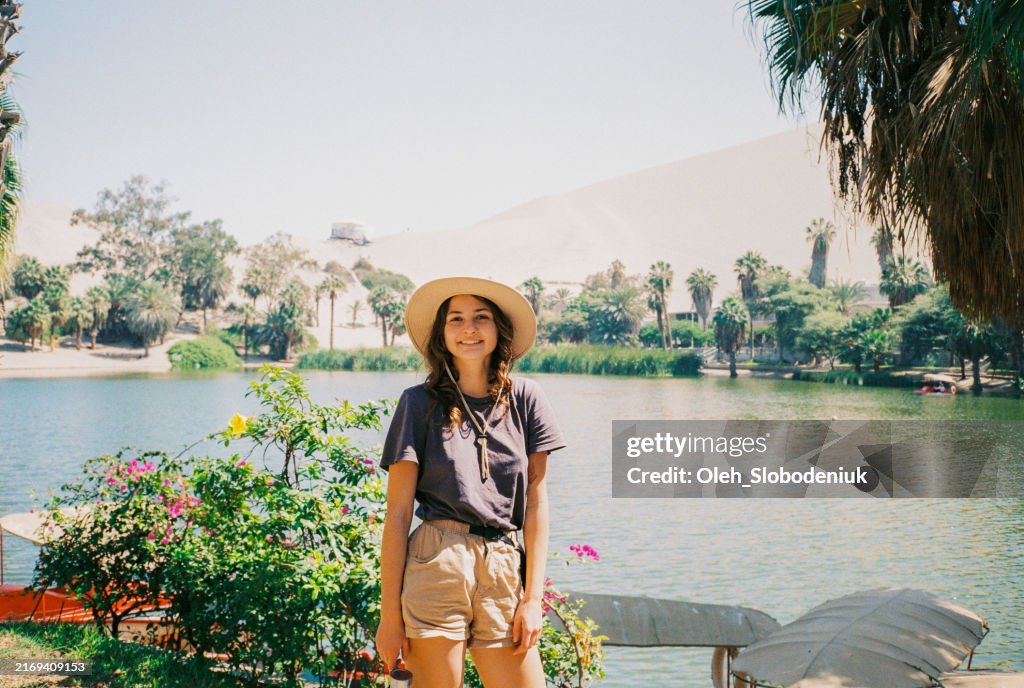 Portrait of woman in Huacachina on the background of the lake shot on camera film