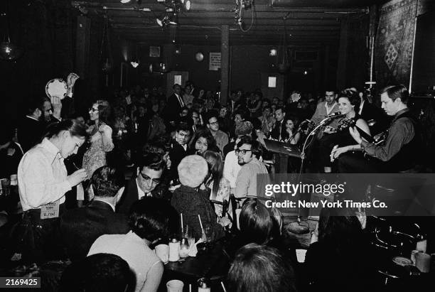 The Feenjon folk group performs on stage for customers at the Feenjon Coffee Shop at 105 MacDougal Street in Greenwich Village, New York City, 1960s.