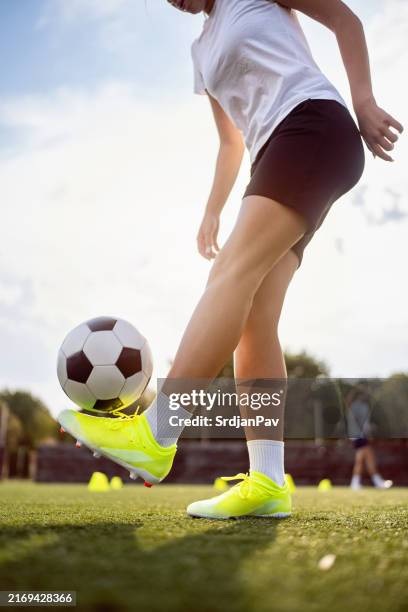 unrecognizable teenage girl, a soccer player juggling the soccer ball during soccer practice - child juggling stock pictures, royalty-free photos & images