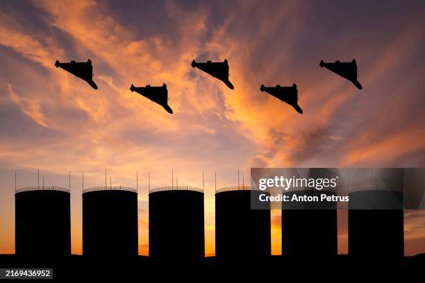 military drones over an oil storage facility - military attack stock pictures, royalty-free photos & images