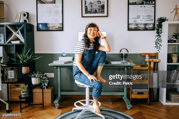 ritratto di allegra bella donna vestita casualmente seduta alla scrivania dell'ufficio di casa - disinvolto foto e immagini stock