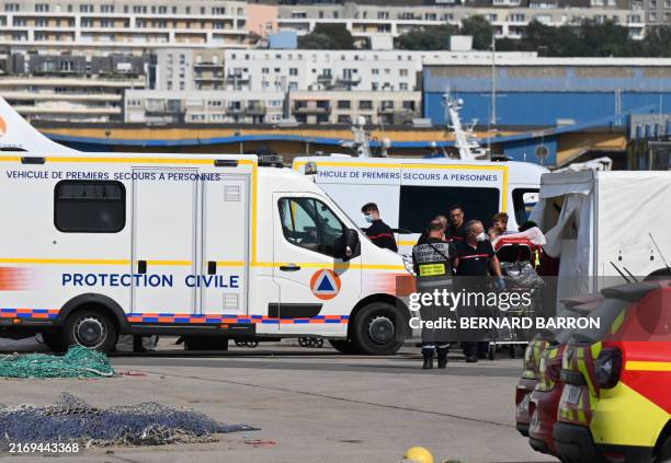 Firefighters provide assistance to an injured migrant after a vessel carrying dozens trying to cross the Channel to England sank off the northern...