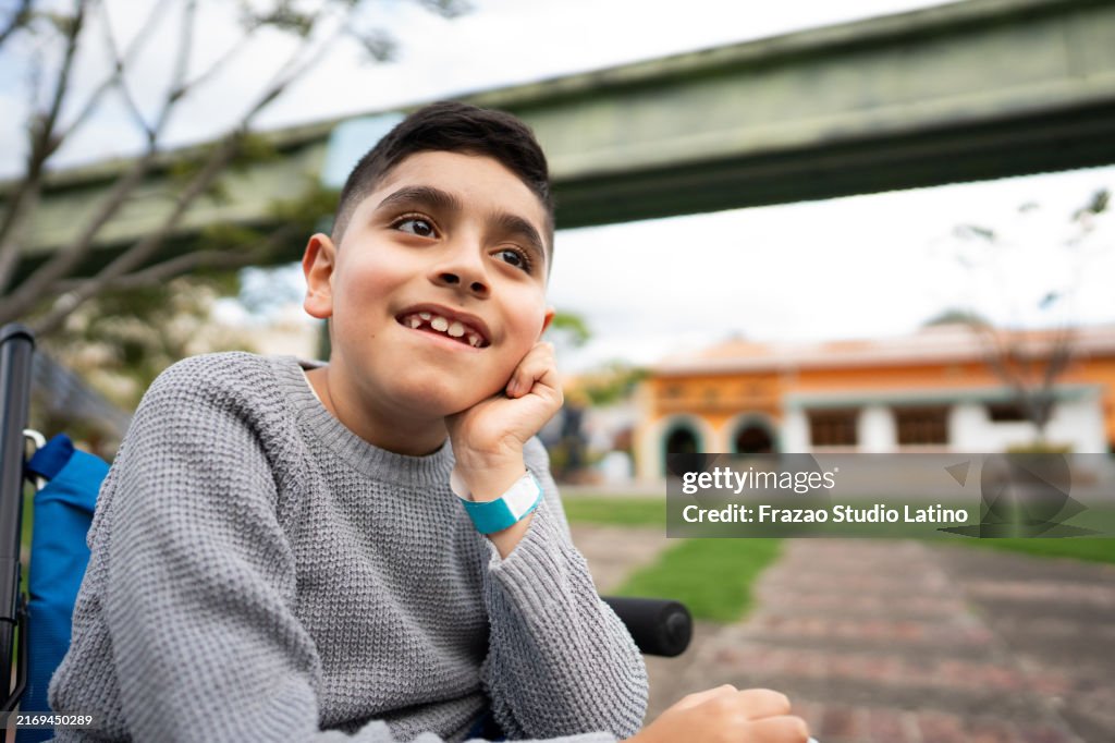 Boy with physical disability contemplating and relaxing on a public park