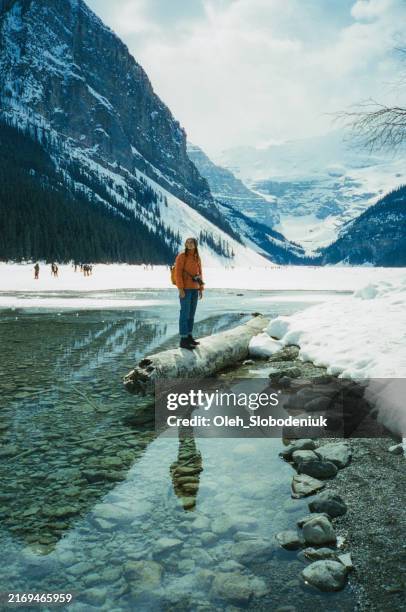 woman exploring lake in banff in winter. shot on camera film - escapismo imagens e fotografias de stock