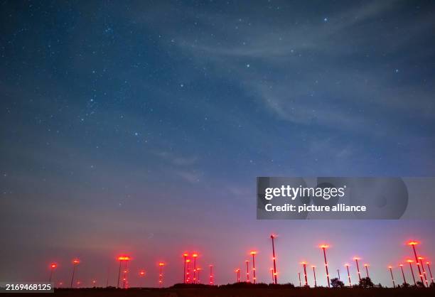 September 2024, Brandenburg, Sieversdorf: Red position lights from wind turbines light up the night sky. Photo: Patrick Pleul/dpa