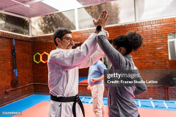 fight instructor with student during exercise class at gym - self defense stock pictures, royalty-free photos & images