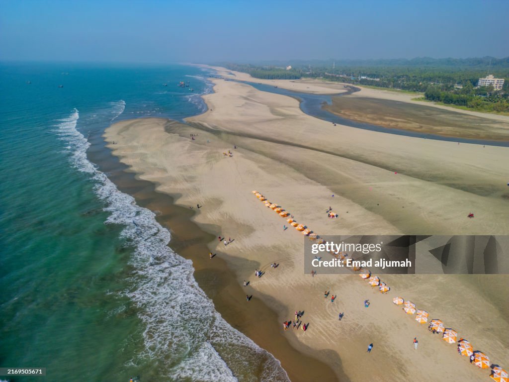 Aerial View of Tourists Enjoying the Beach with Umbrellas in Coxs Bazar, Bangladesh