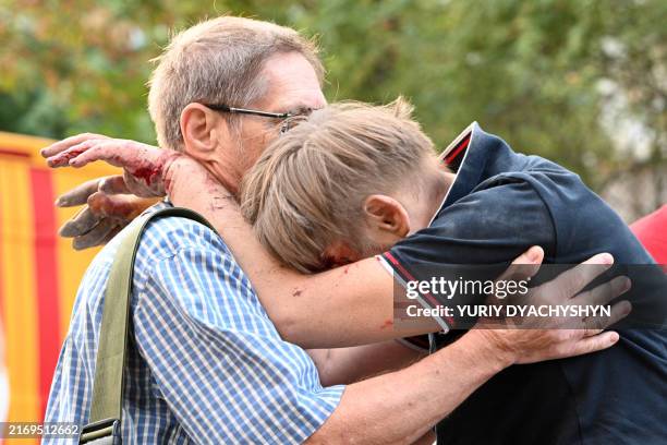 Man comforts injured local resident Jaroslav Bazylevych whose family was killed in a missile attack in Lviv on September 4, 2024. A Russian strike on...