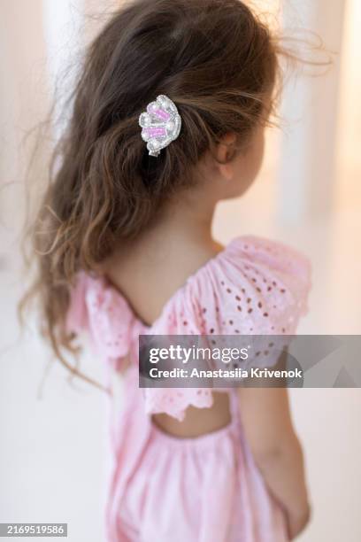 rear view of little girl in pink jumpsuit with hair pin. - haarspange stock-fotos und bilder