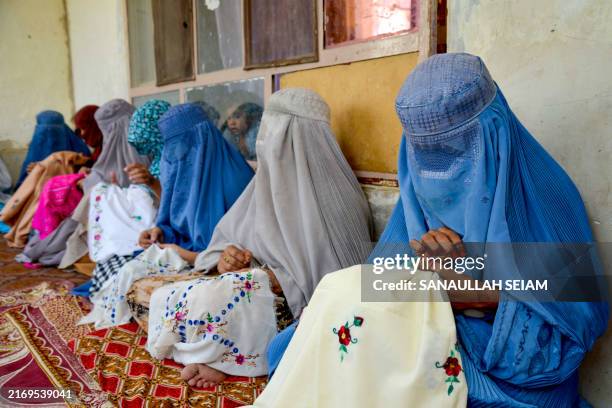 Afghan burqa-clad women embroider handkerchiefs at a workshop in Kandahar on September 4, 2024.