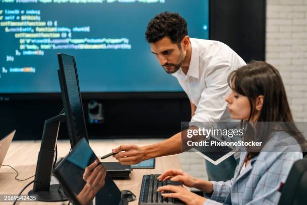 two software developers checking programming code on computer screen. - application developer stock pictures, royalty-free photos & images