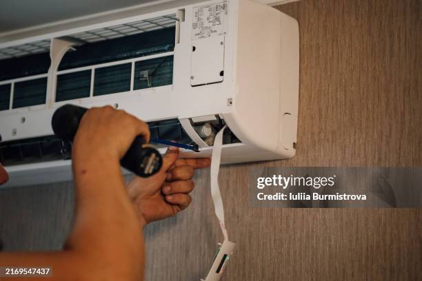 hands of unrecognizable man installing blinds to clean air conditioner after purifying. - respiratory protection construction stock pictures, royalty-free photos & images