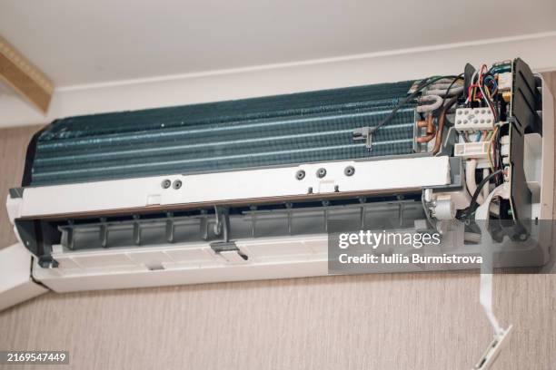 freshly cleaned air conditioner hanging from ceiling in corner of room and purifying air in new way, protecting health of households. - respiratory protection construction stock pictures, royalty-free photos & images