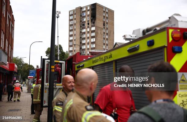 Members of London Fire Brigade work near their appliances after a fire at a block of flats in the Catford suburb of south London on September 4,...
