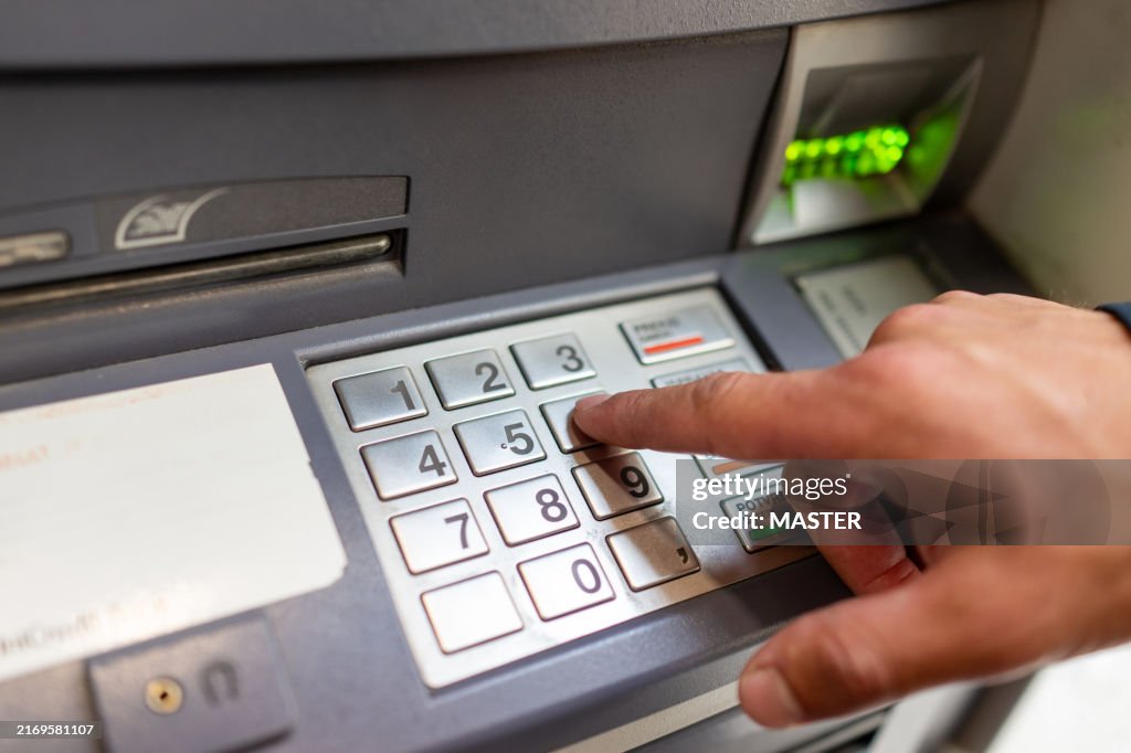 Male Hand Inserting PIN code into the ATM Machine