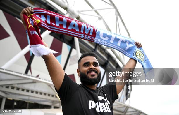 General view outside the stadium, as a fan holds up a half and half scarf prior to the Premier League match between West Ham United FC and Manchester...
