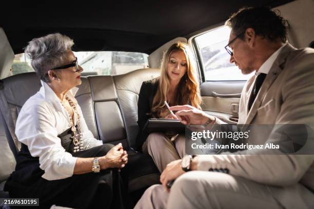 business team having corporate meeting in backseat of limousine - high society stock pictures, royalty-free photos & images