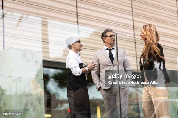 business people having conversation about work strategy outdoors - rich people talking stock pictures, royalty-free photos & images