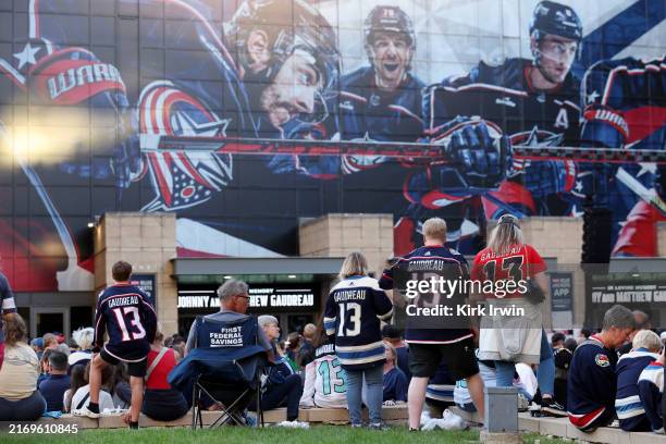 Columbus Blue Jackets fans wear the jersey of Johnny Gaudreau during a candlelight vigil in remembrance of Johnny and Matthew Gaudreau at Nationwide...