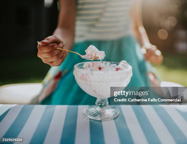 close-up, soft focus image of a child eating ice cream from a crystal cut glass ice cream dish - gefrorener joghurt stock-fotos und bilder