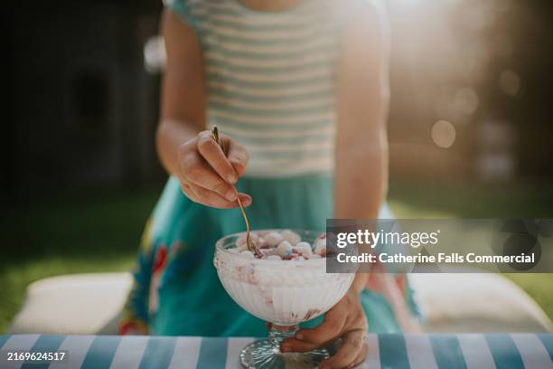 close-up, soft focus image of a child eating ice cream from a crystal cut glass ice cream dish - eisbecher stock-fotos und bilder
